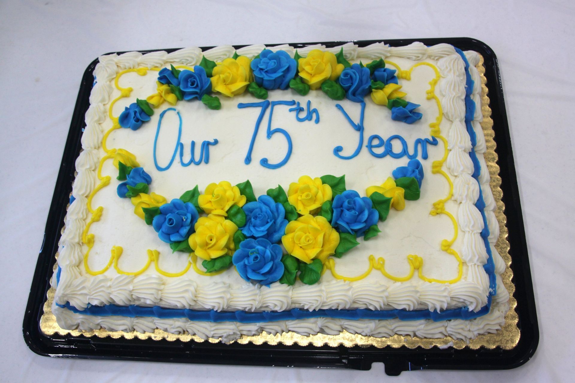 A 75th anniversary cake with blue and yellow frosting
