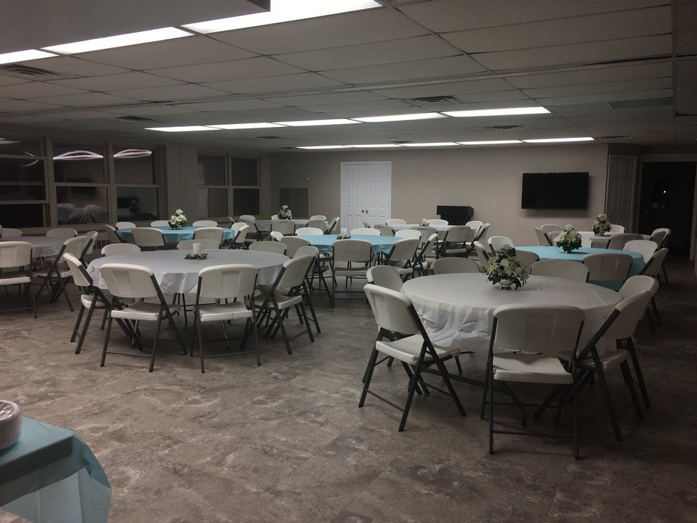 A large room with tables and chairs set up for a party