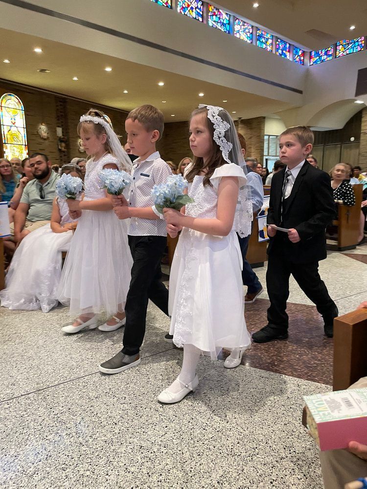 A group of children are walking down the aisle of a church.