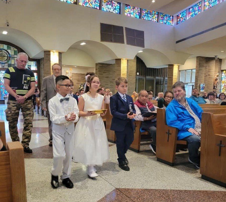 A group of children are walking down a church aisle