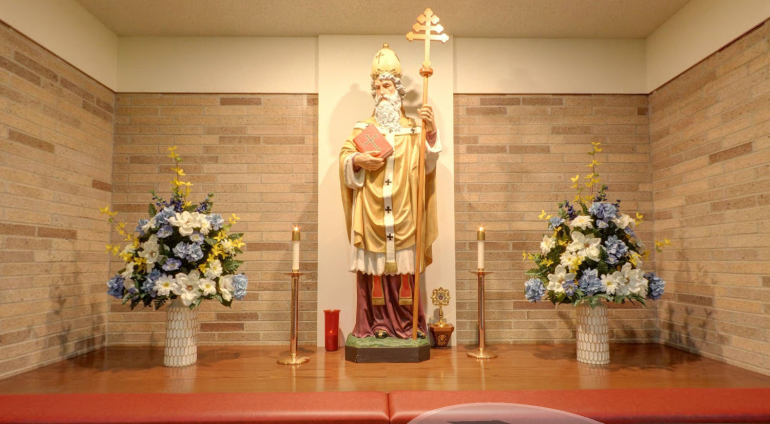 There is a statue of St. Leo the Great in a room with flowers and candles.