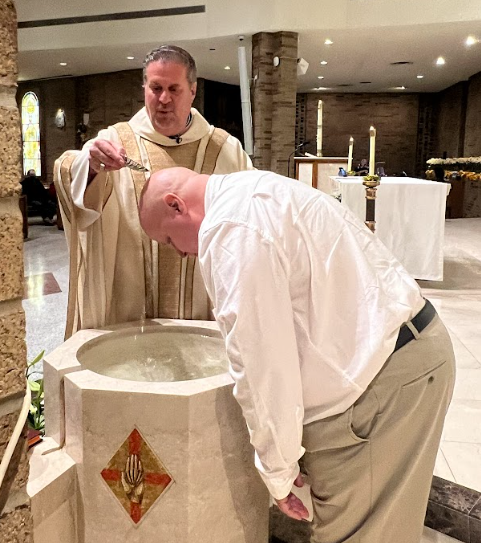 a man is being baptized by the priest