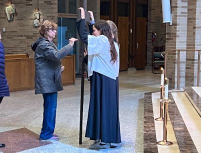 A group of people are standing in a church talking to each other.