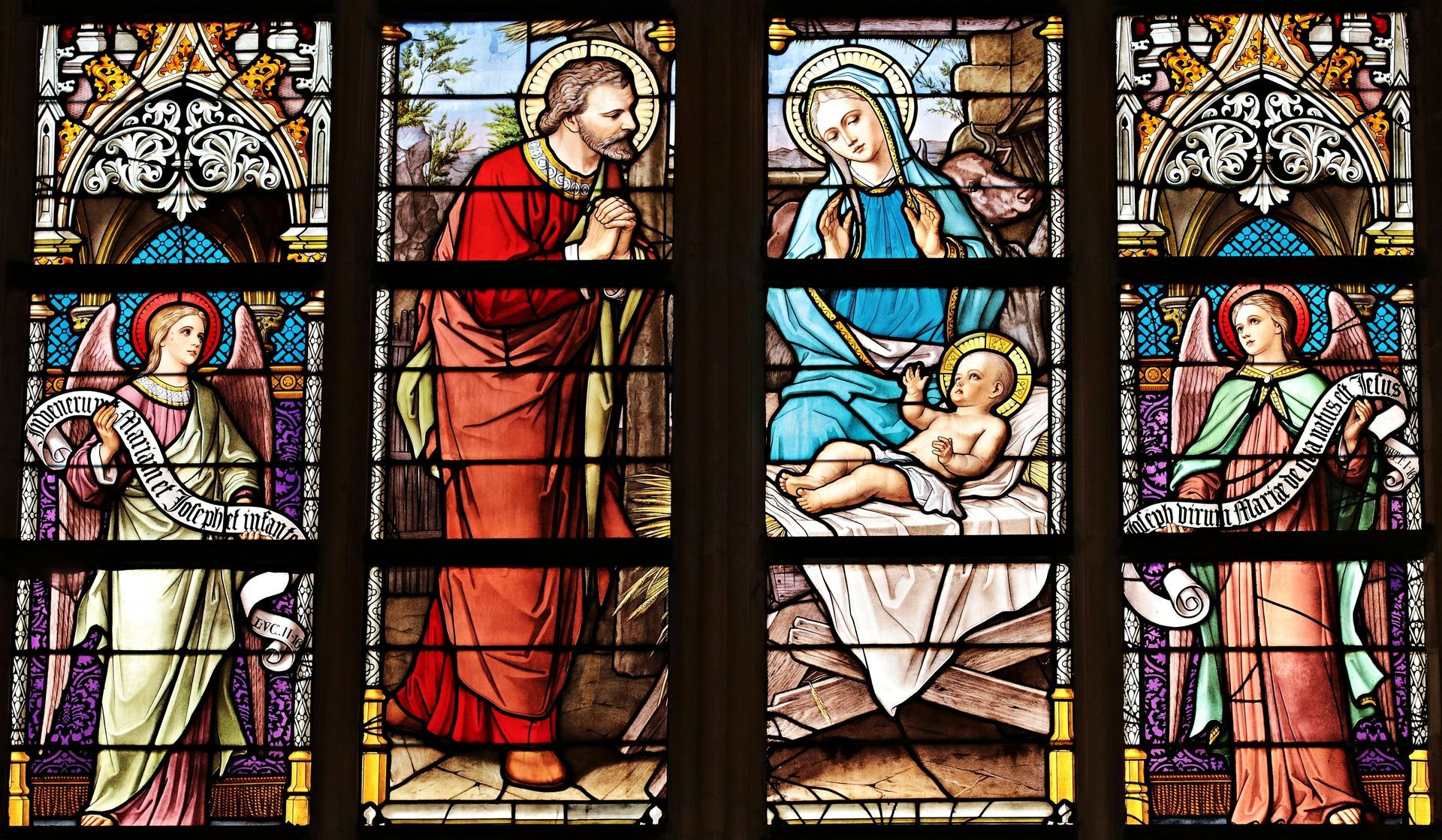 A stained glass window in a church depicting the nativity scene