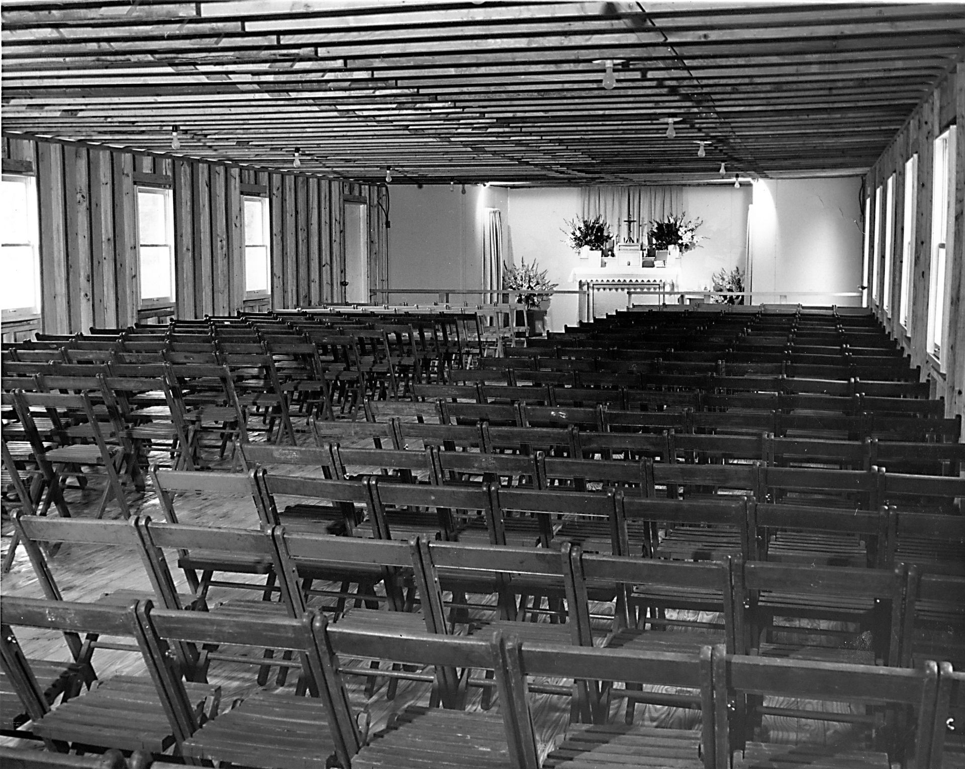 Rows of wooden folding chairs in a large room