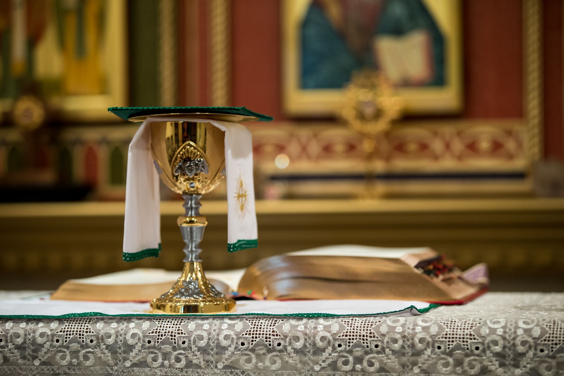 A chalice and a bible are on a table in a church.