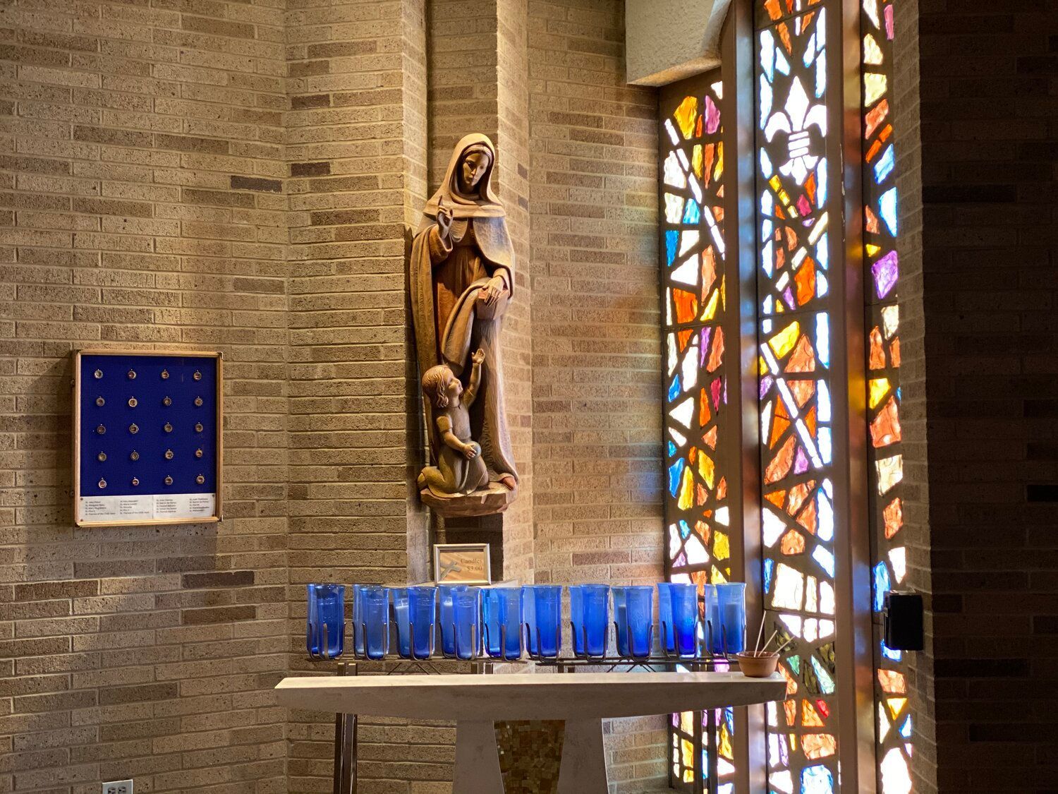 A church with a statue of mary and a stained glass window