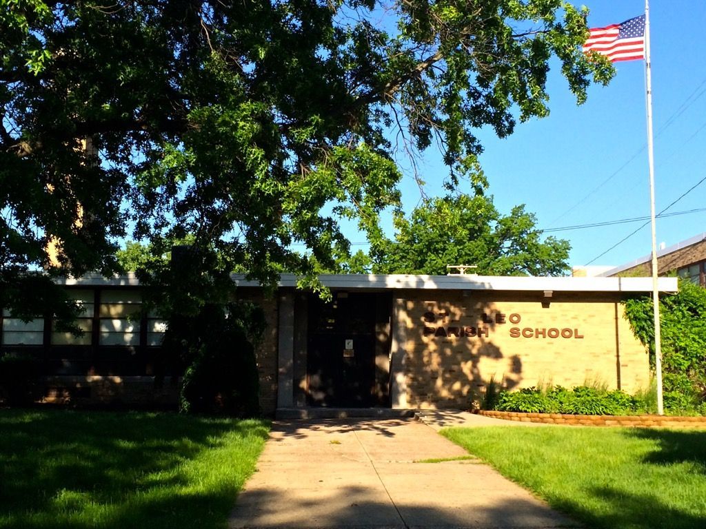 An american flag is flying in front of a school building