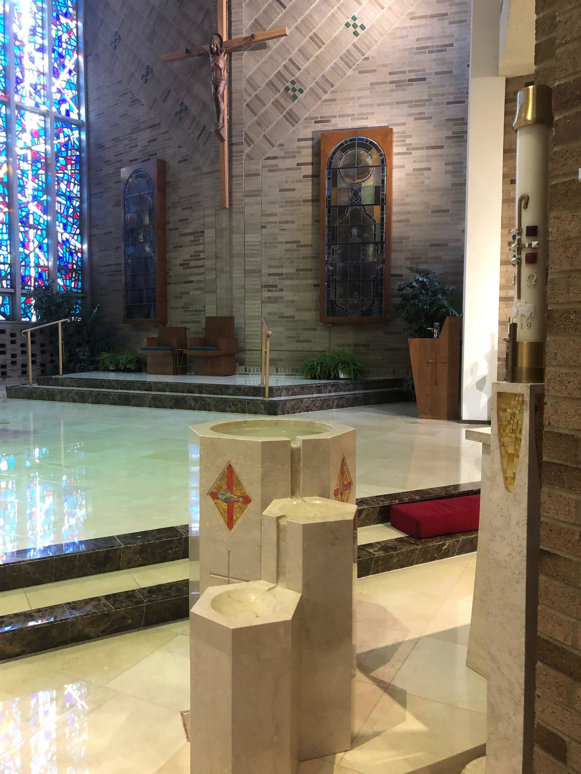 A church with a stained glass window and a cross on the wall