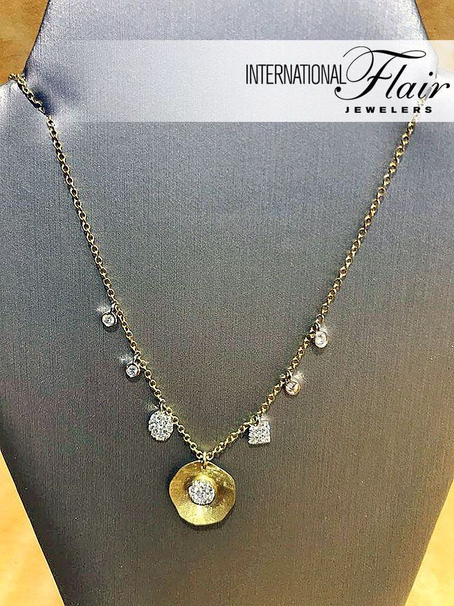 A gold necklace with a diamond pendant is on a mannequin.