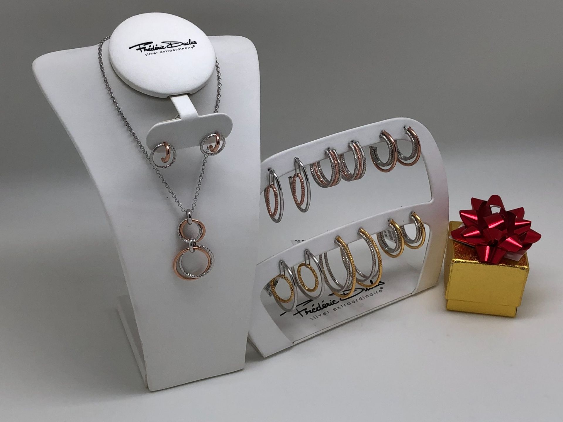 A necklace and earring set on a mannequin next to a gift box