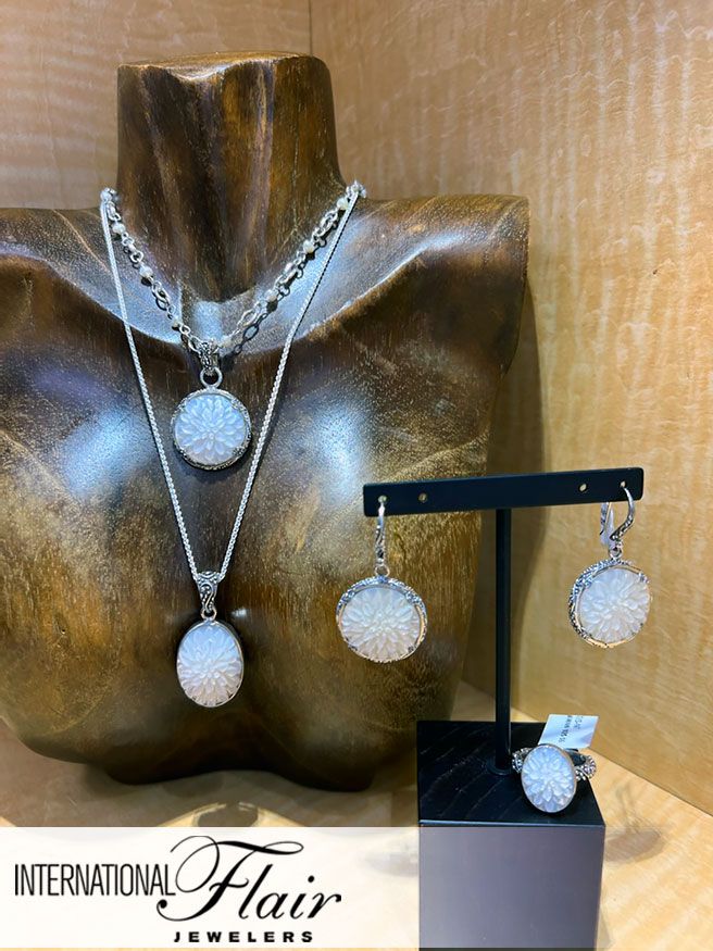 A necklace , earrings , and ring are displayed on a mannequin.