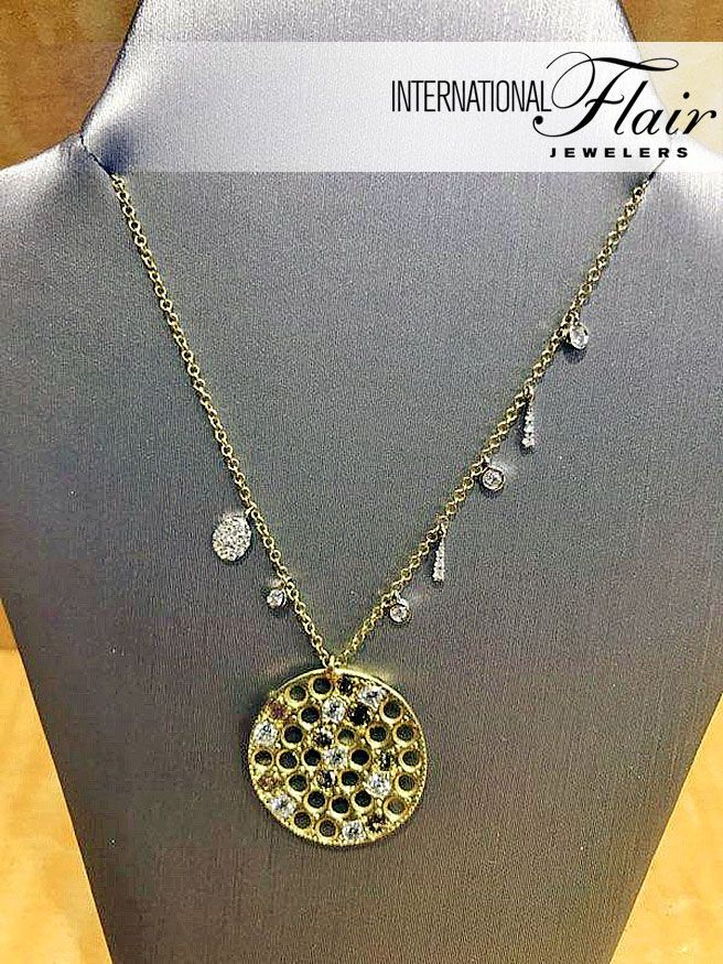 A necklace with a round pendant is on a mannequin.