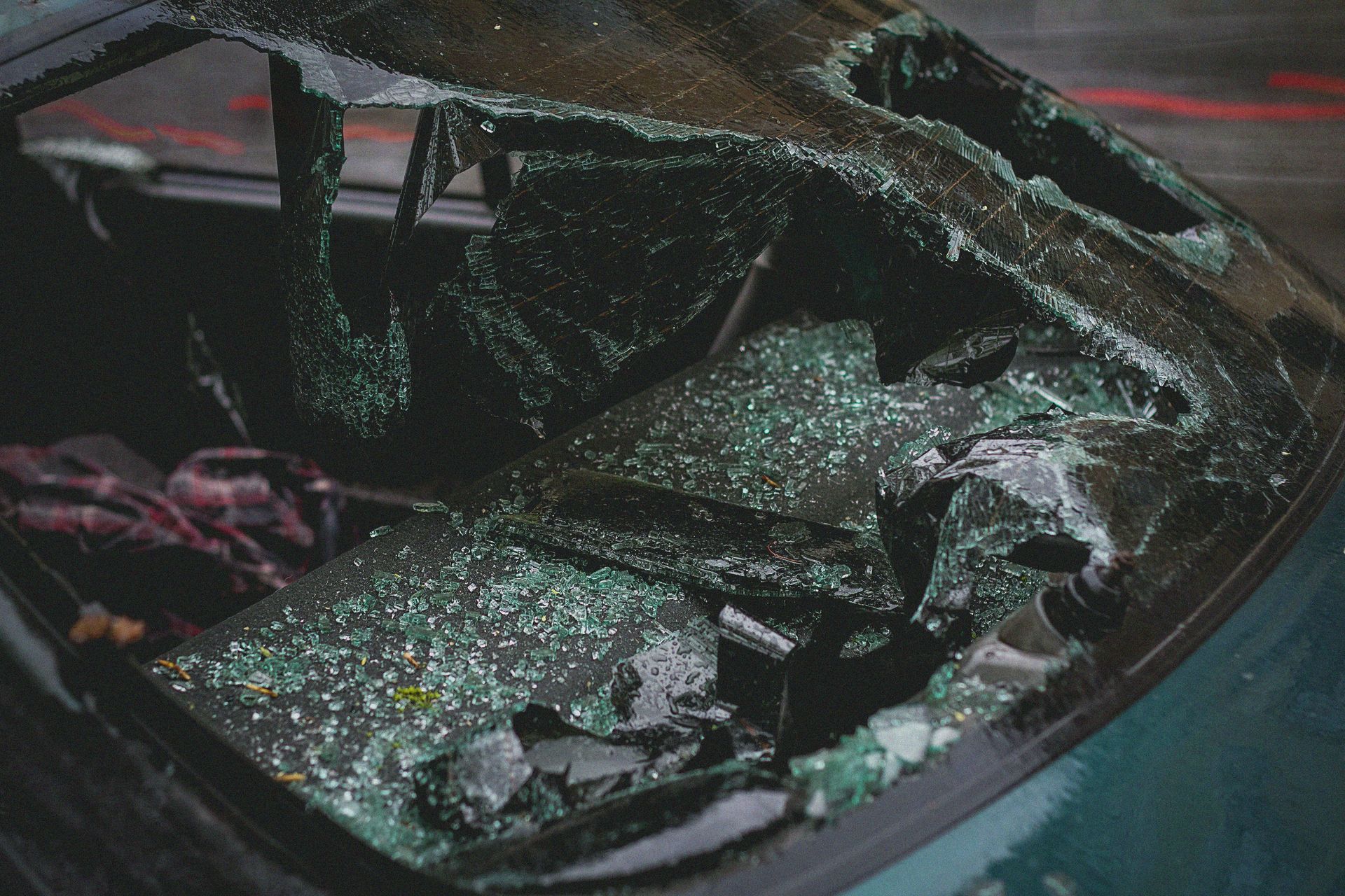 Shattered car windshield with visible cracks and glass fragments.