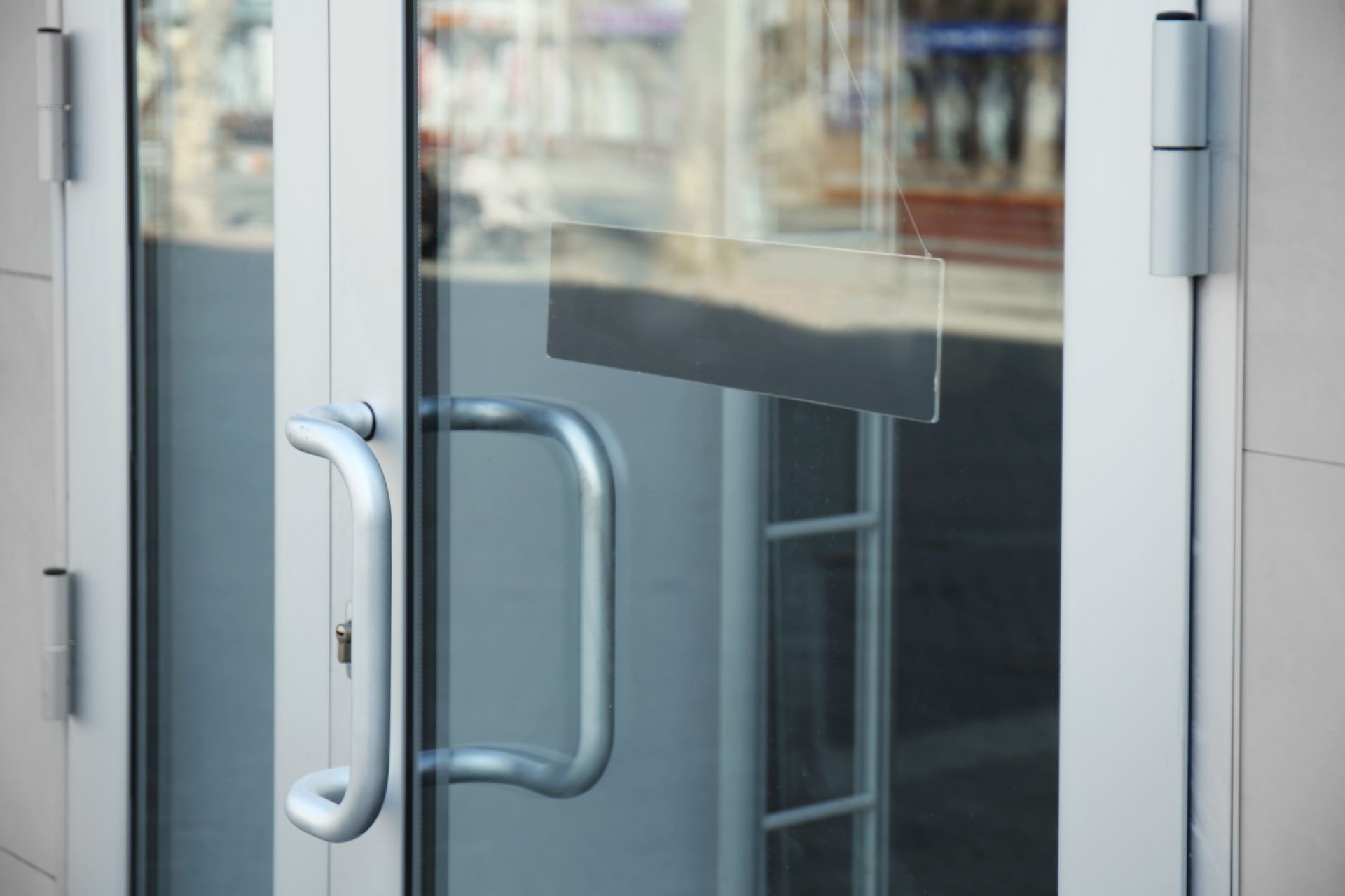Silver-handled glass door at a storefront glass shop.