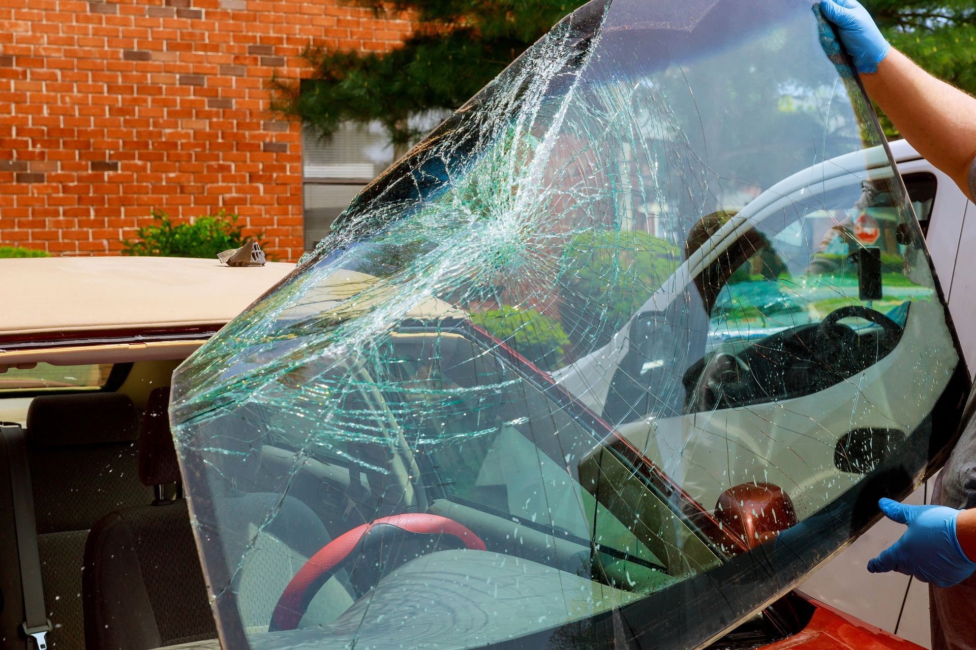 A person is fixing a broken windshield on a car.