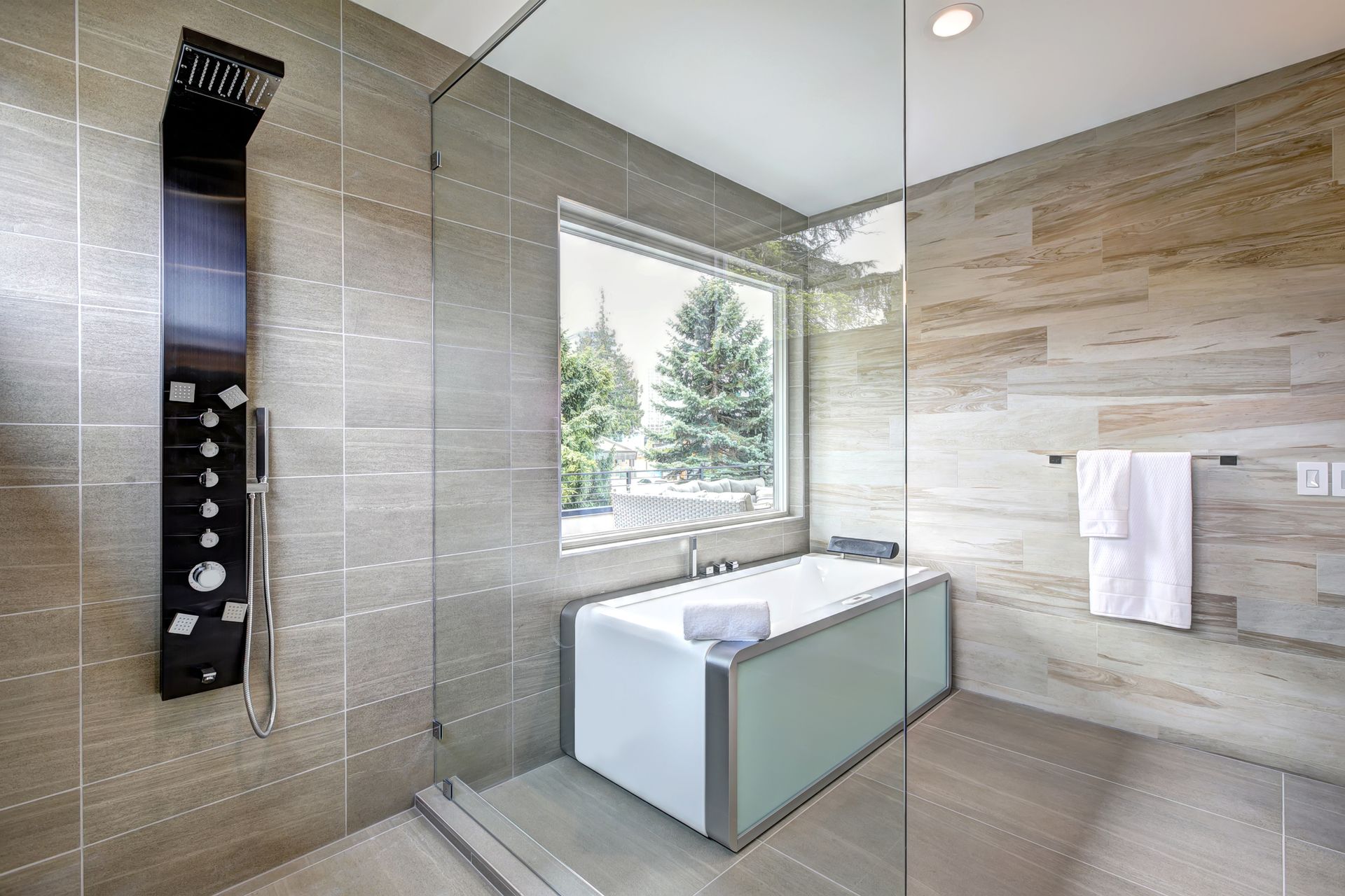 A contemporary master bathroom features a modern tub and glass walk-in shower.