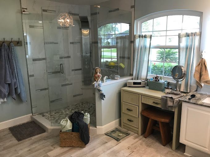 A bathroom with a walk in shower and a vanity.