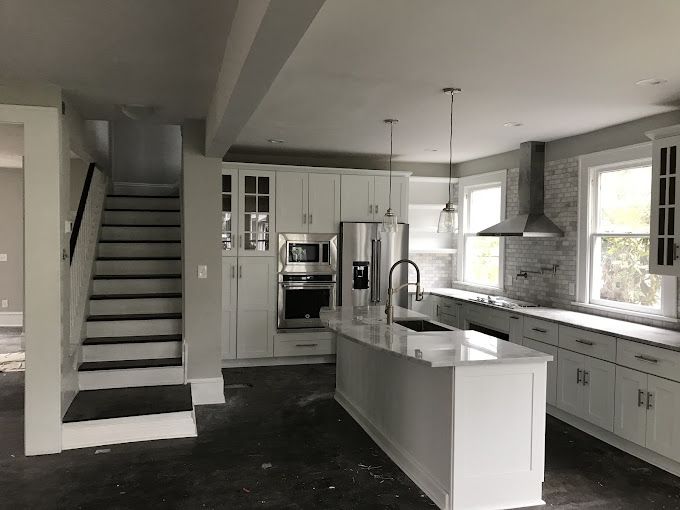A kitchen with white cabinets and a large island.