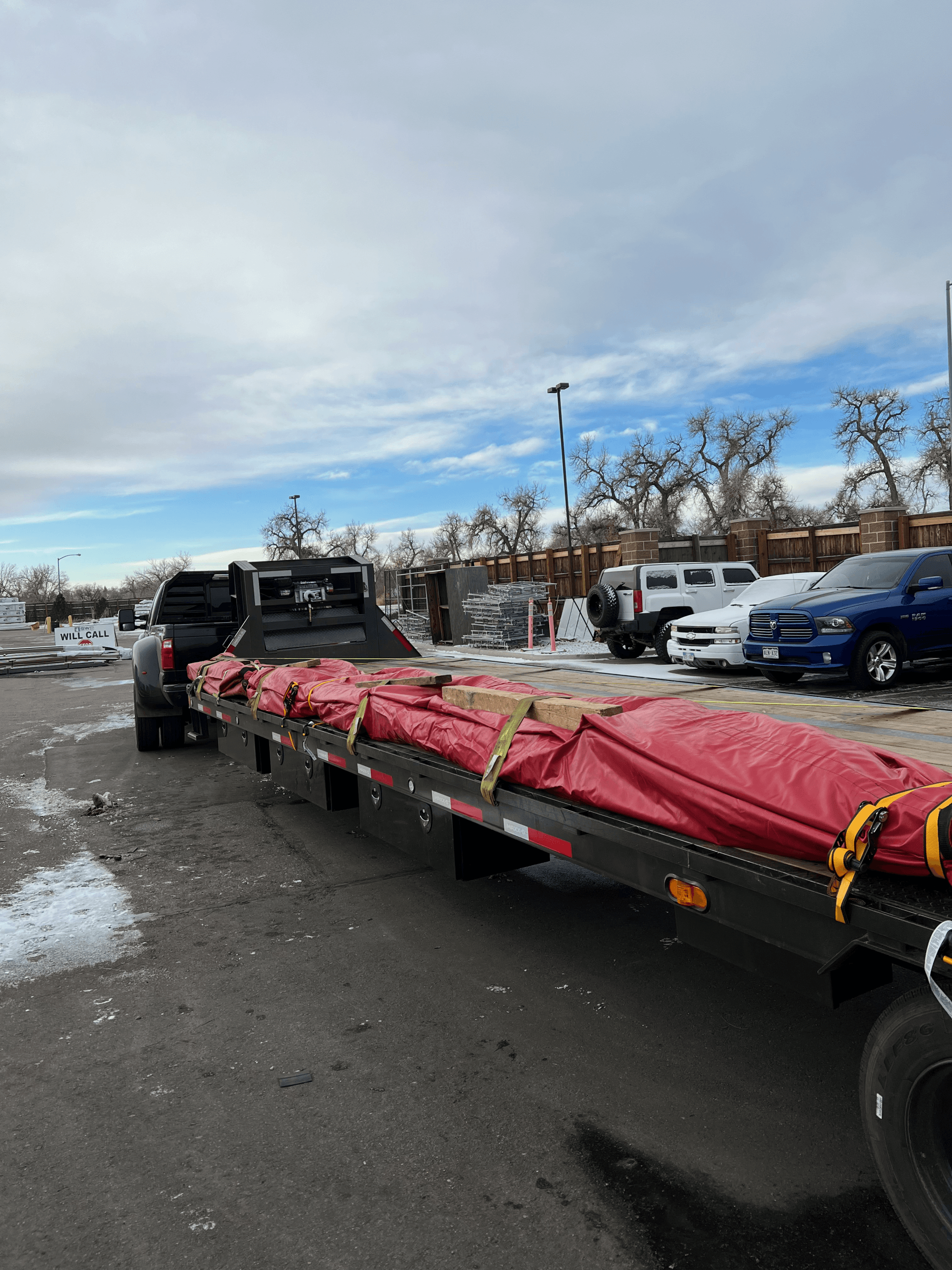 construction materials tarped and strapped on flatbed trailer