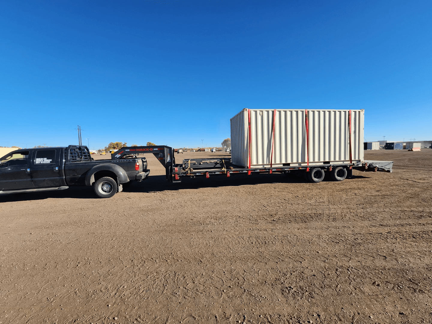storage container strapped on flatbed trailer to be transported