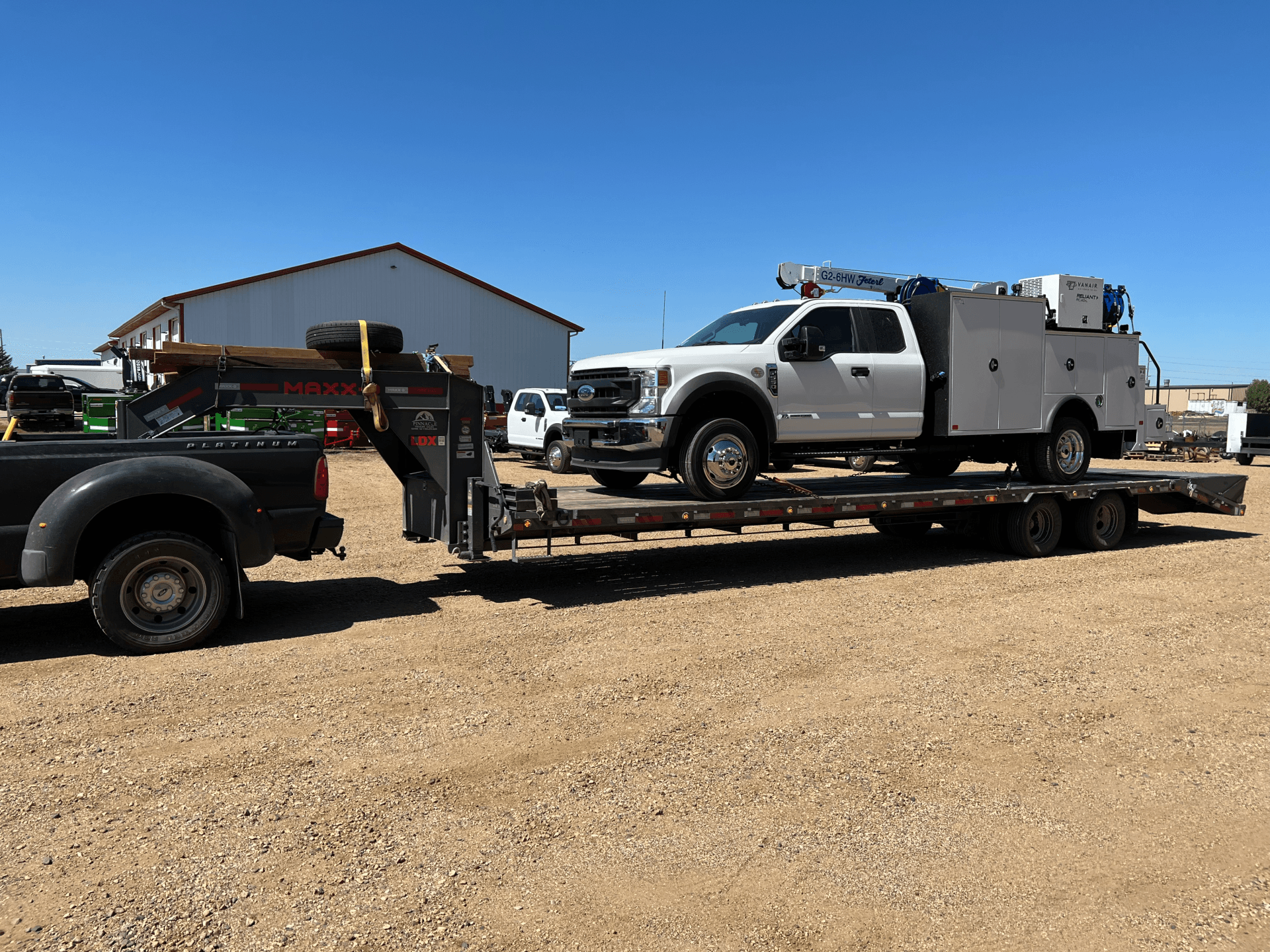pickup truck on flatbed trailer strapped and ready to be transported