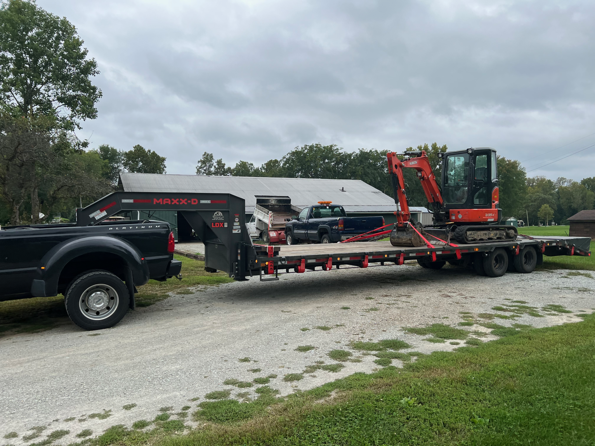 red backhoe on trailer to be transported