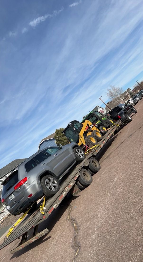 car, skidster, and cart being transported on flatbed trailer by haul3d