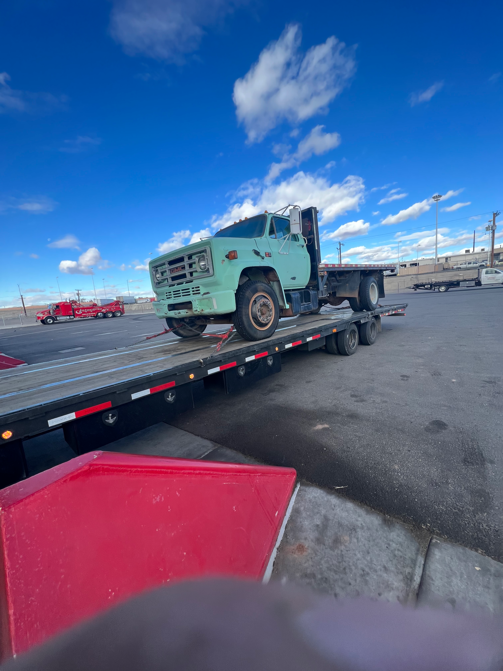old pickup truck with a flatbed being hauled and loaded on to haul3d's flatbed trailer