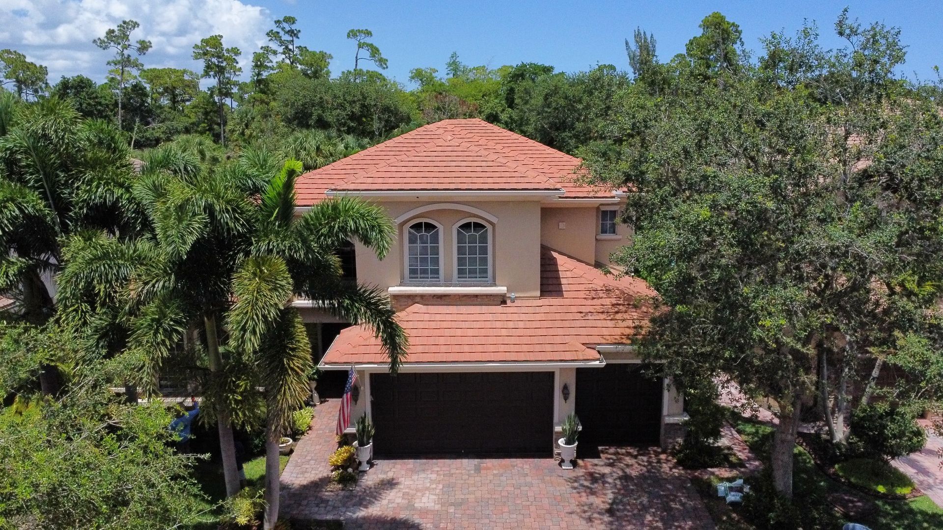 A brick driveway with a grill cover on it.