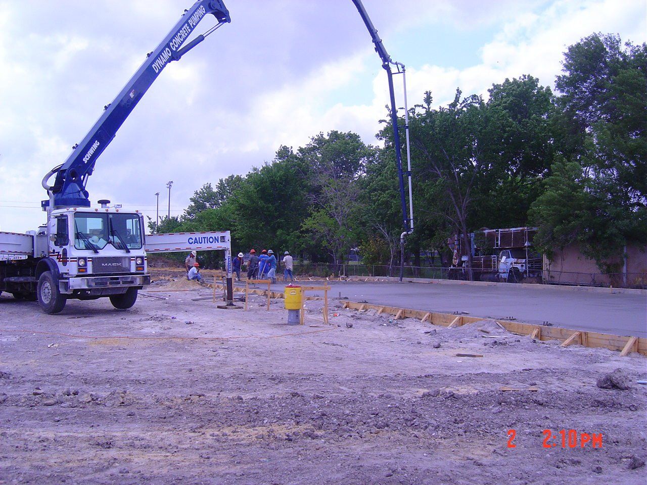 Construction workers troweling wet concrete - Deer Park, TX - DH Construction