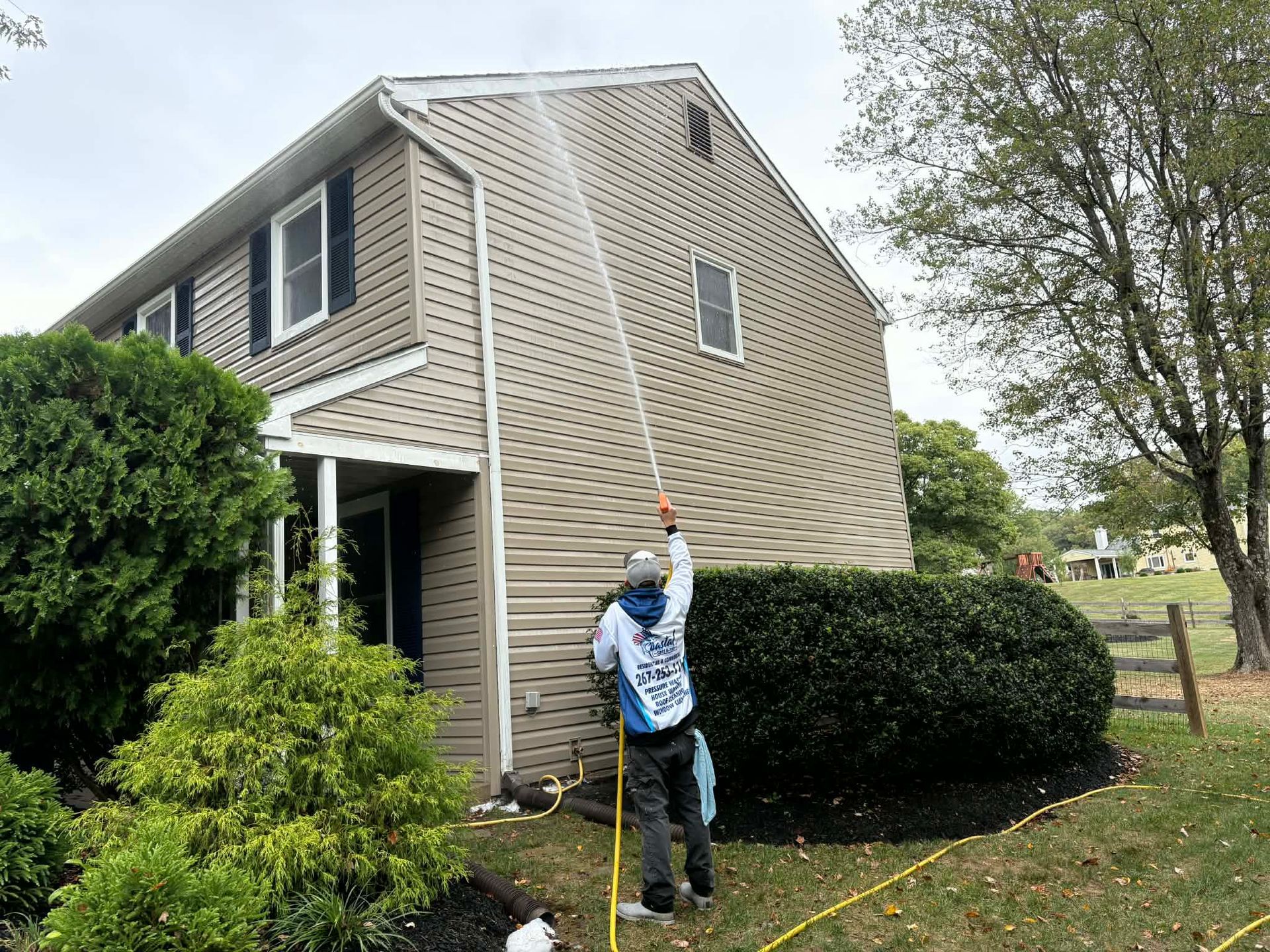 Pressure washing siding of house