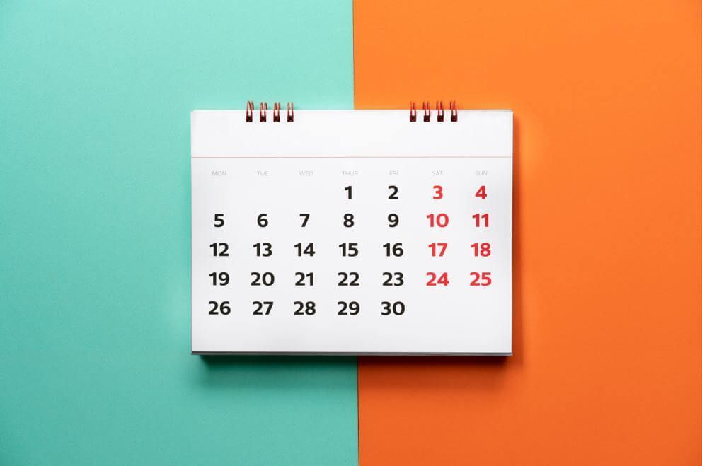 A calendar is sitting on a blue and orange background.