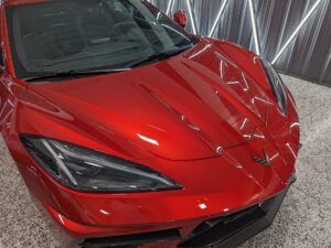 A red sports car is parked in a garage.