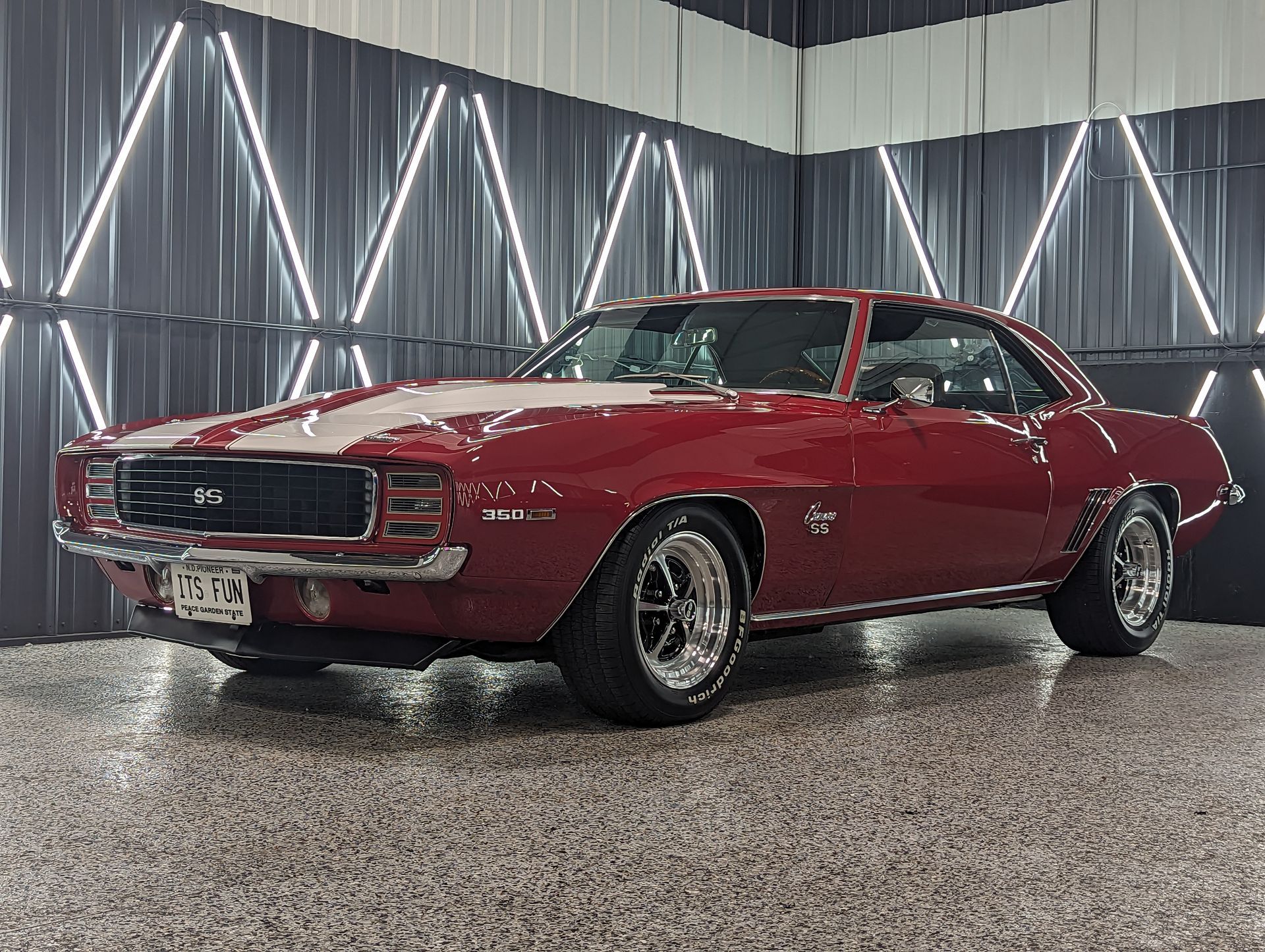 A red chevrolet camaro is parked in a garage.