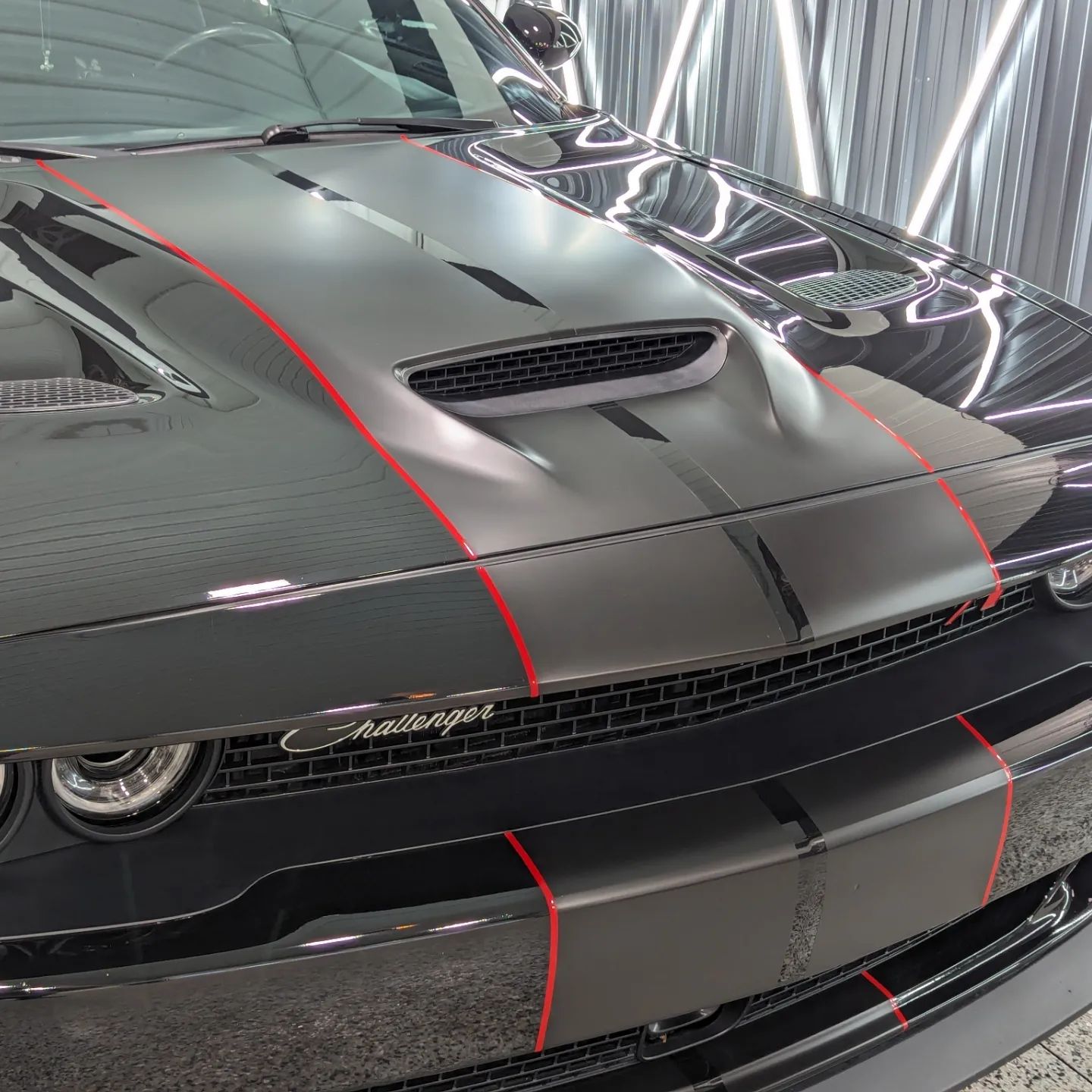 A black mercedes benz is parked in front of a garage.