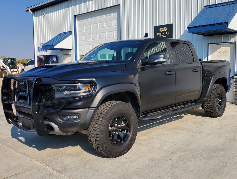 A black truck is parked in front of a building.