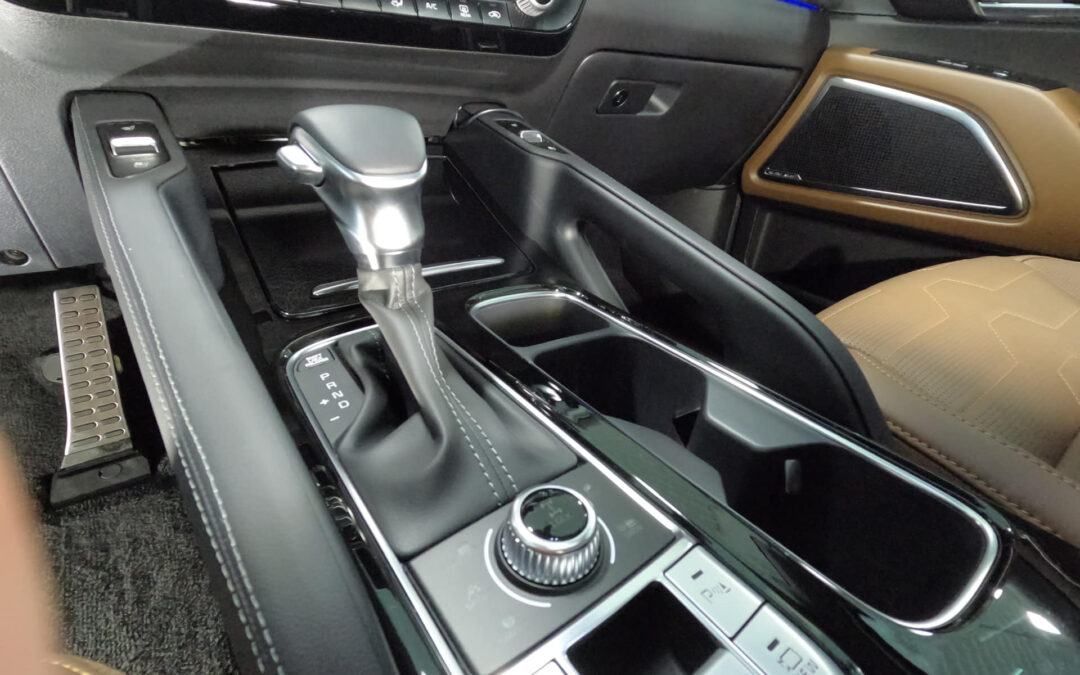 The interior of a car with a shifter and a cup holder.