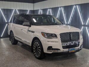 A white lincoln navigator is parked in a showroom.