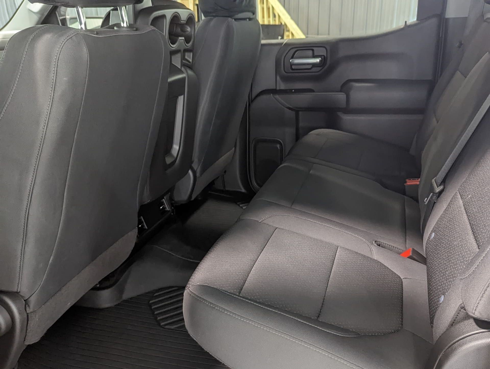 The back seat of a truck with a ladder in the background.