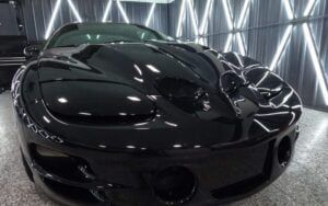 A black sports car is parked in a garage.