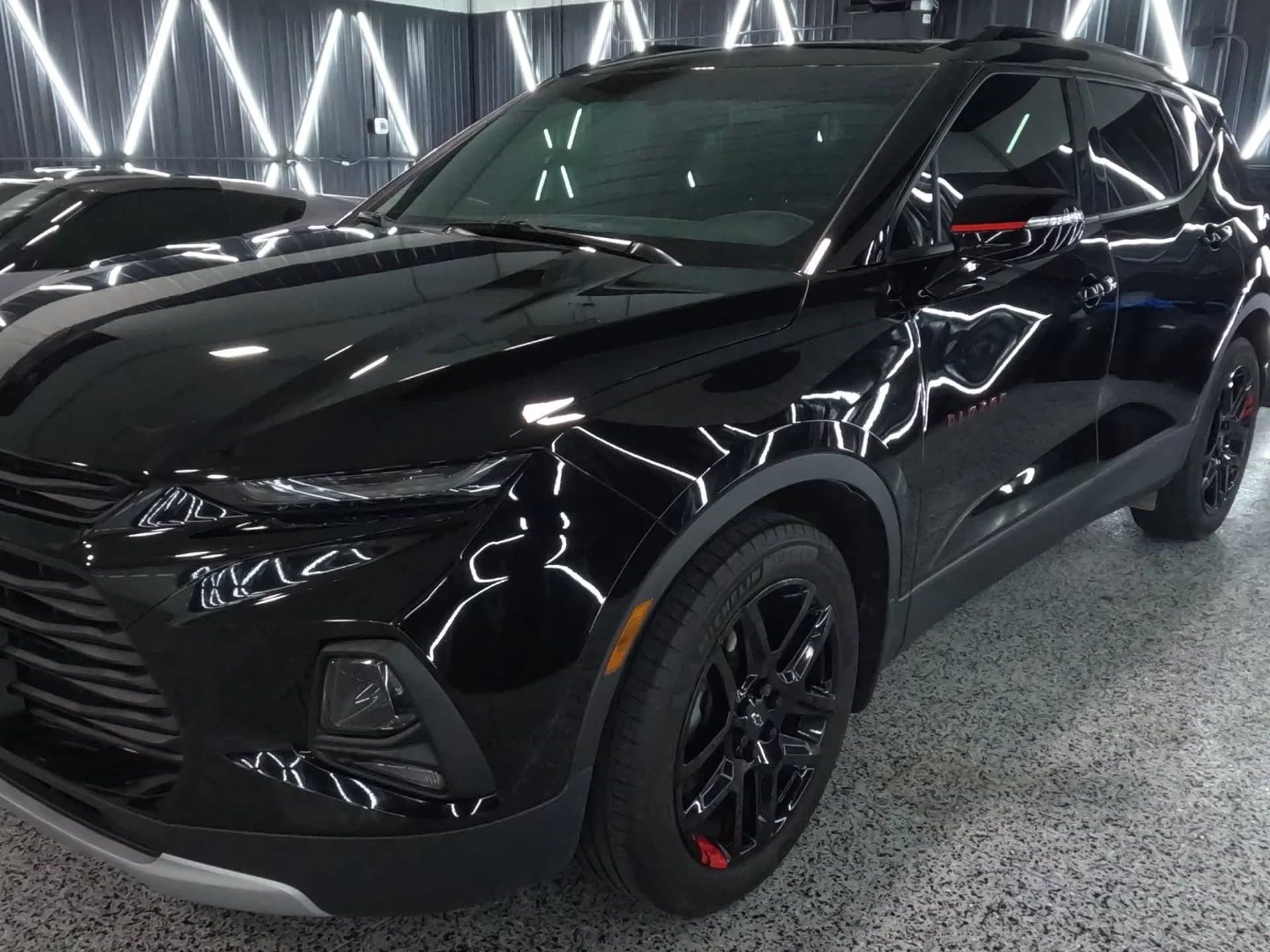 A black chevrolet blazer is parked in a garage.