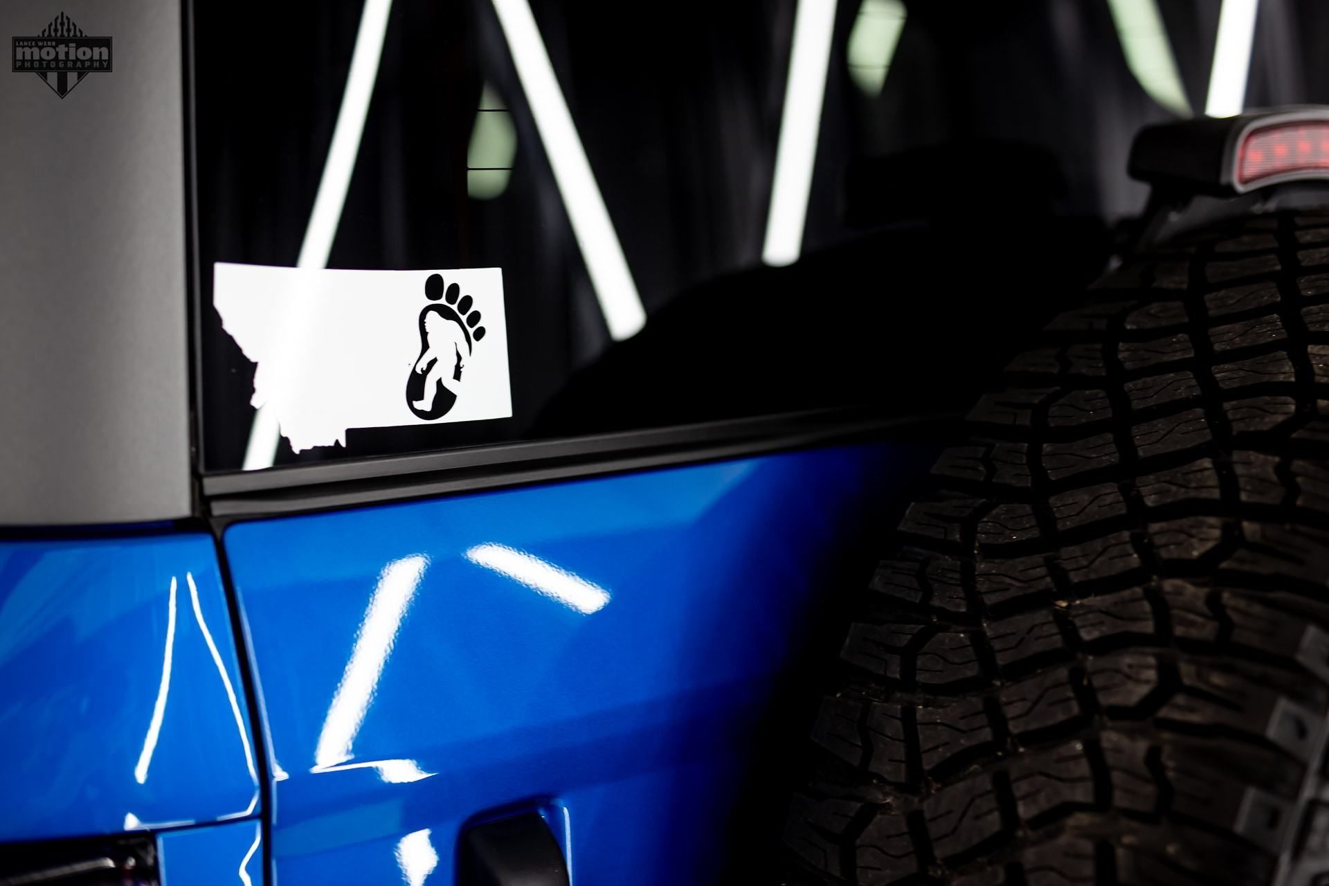 A close up of a blue car with a sticker on the window