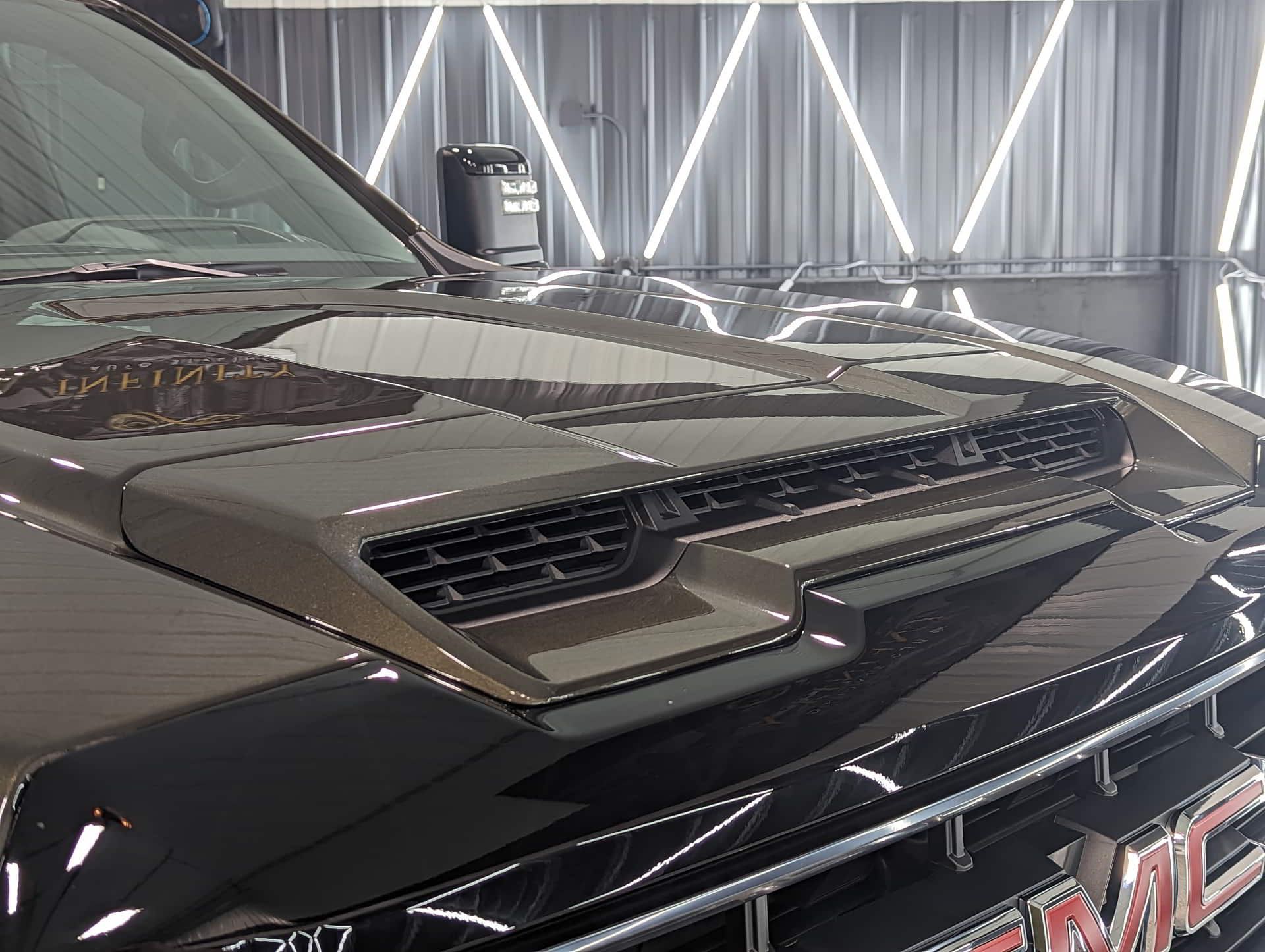 A black gmc truck is parked in a garage.