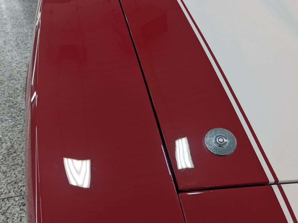 A close up of a red car with white stripes