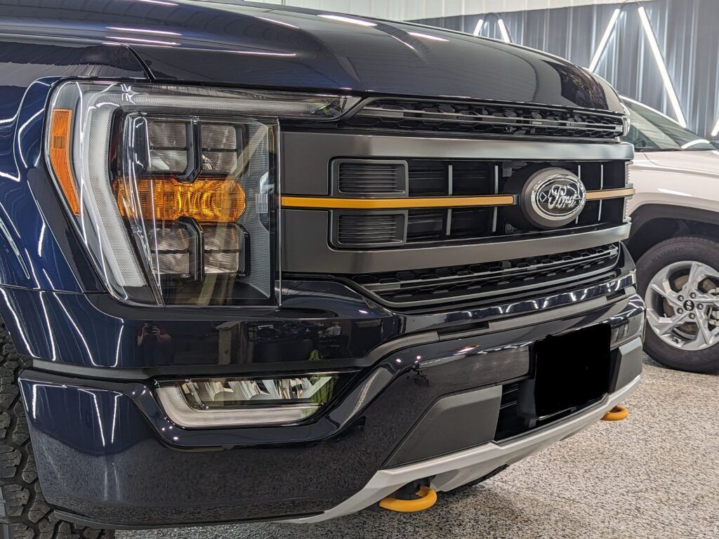 A blue ford f150 is parked in a showroom.