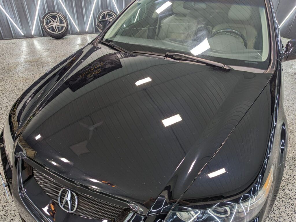 A black acura integra is parked in a garage.