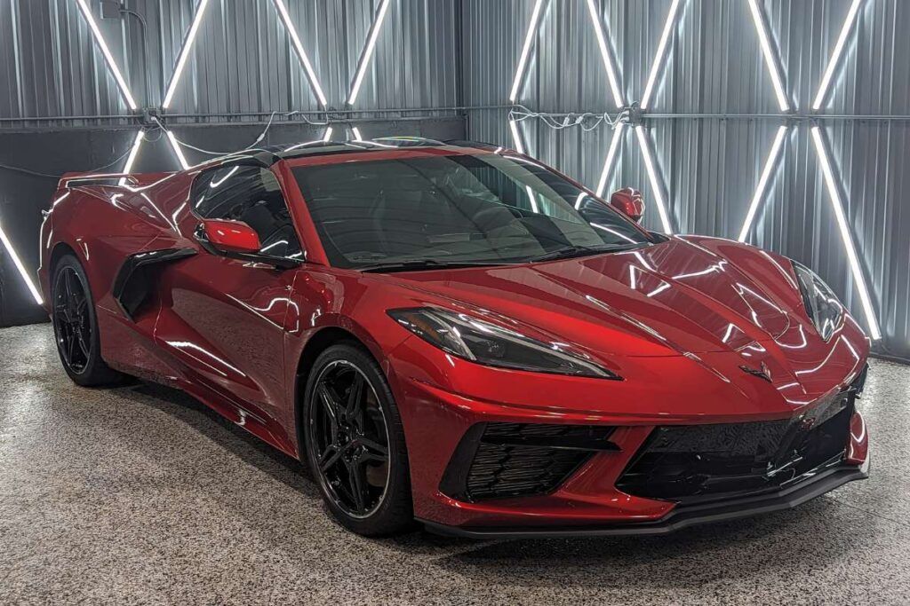 A red sports car is parked in a garage.