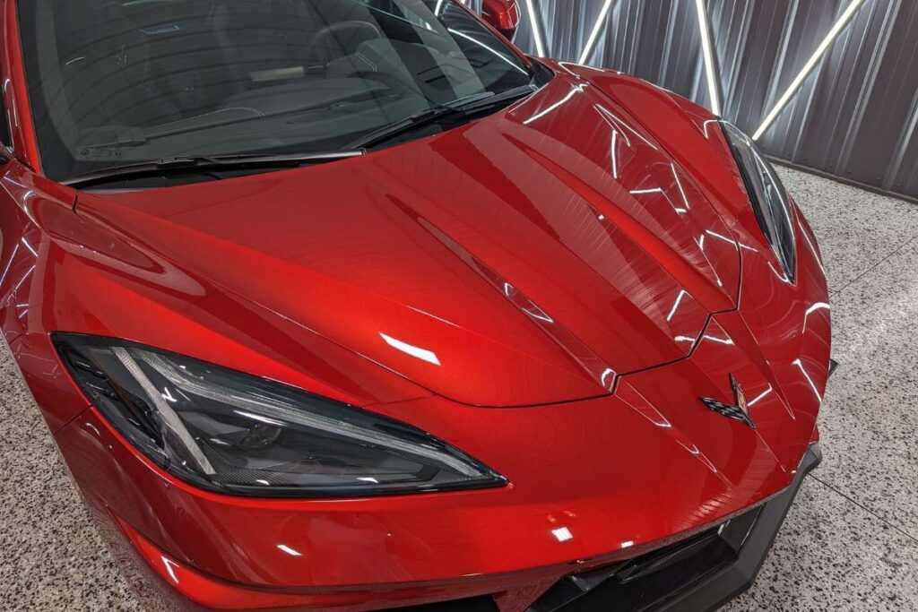 A red sports car is parked in a garage.