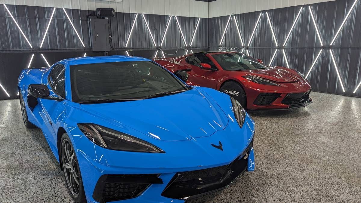 Two blue and red sports cars are parked in a garage.